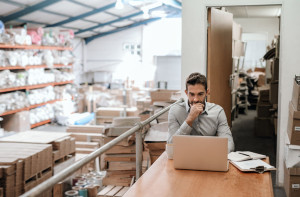 Manager working online while sitting in a warehouse office